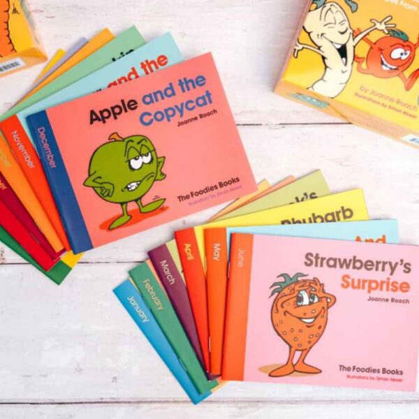 The Foodies Books - twelve months of veggie patch stories spread in two piles with a strawberry and apple story showing on top of each pile, square image.