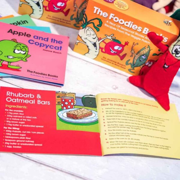 An image of a Foodies veggie patch stories recipe page showing a book with the pages open to the children's recipe at the back and some other products in the background.