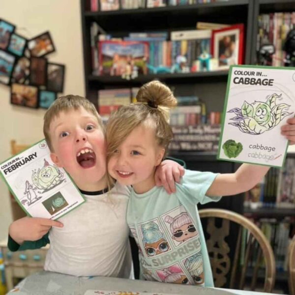 The Little Foodies Club food programme for kids, image of two joyful kids using the box and holding up their vegetable colouring with pride.