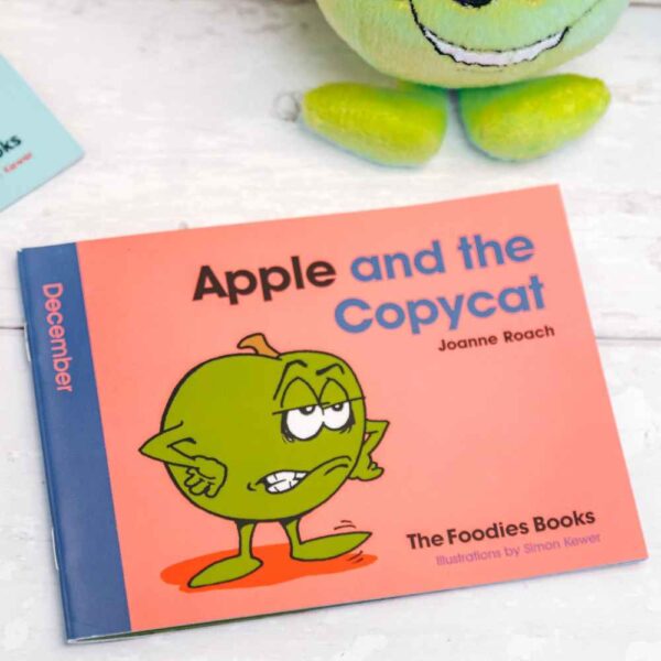 A flatlay image of the book Apple And The Copycat – The Foodies veggie patch story for December, on a worktop background.